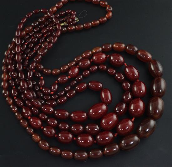 Three assorted simulated cherry amber graduated bead necklaces and one other necklace,